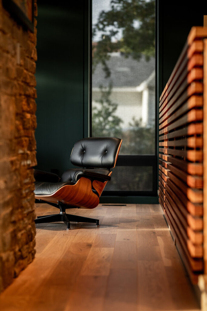 Slatted wood wall in a hallway with a lounge chair