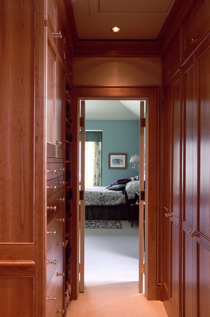 Cherry wardrobe cabinets lining a walk-through to a bedroom
