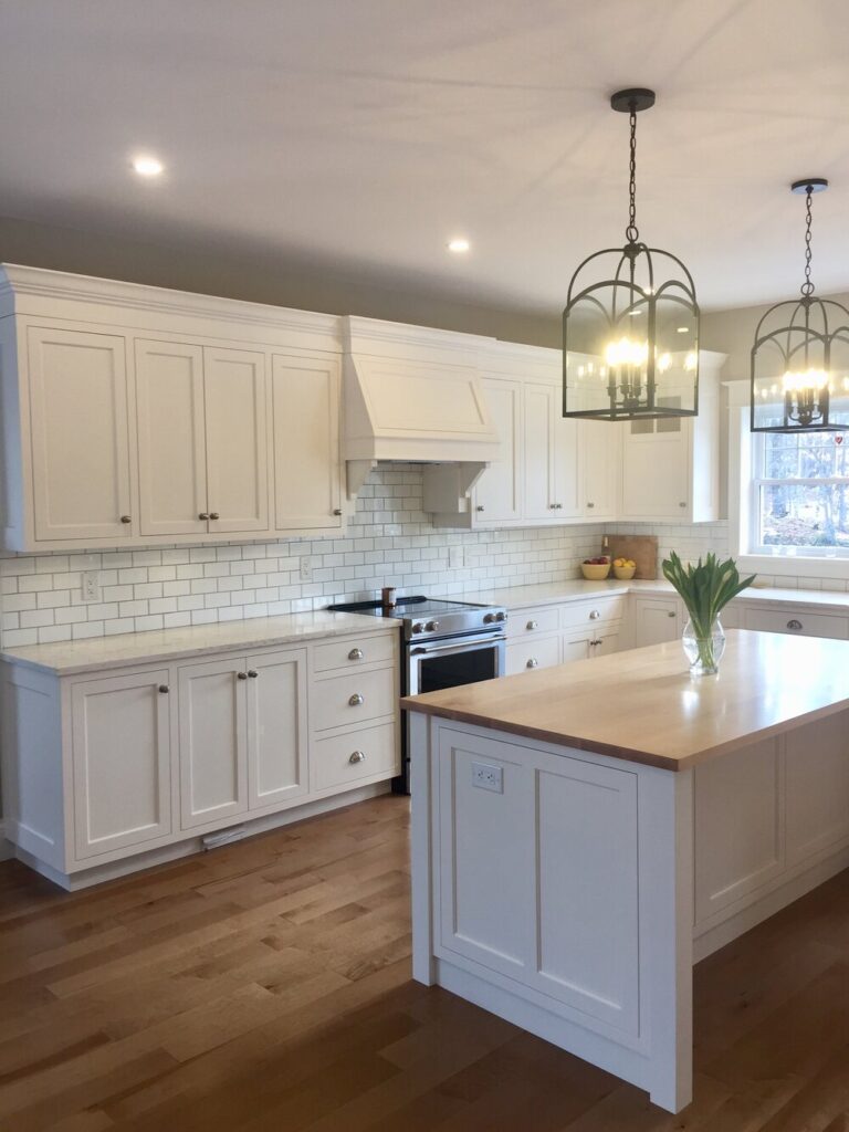 White kitchen with a subway tile backsplash and a butcher-block island top