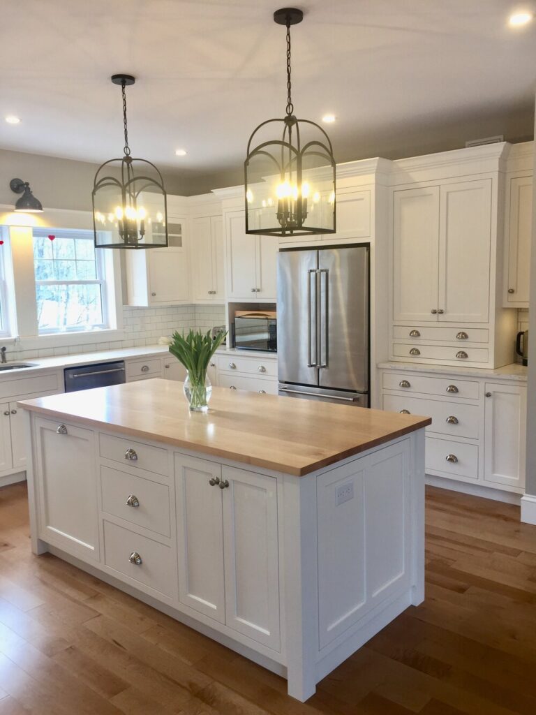 White island with a butcher-block top under lantern pendants