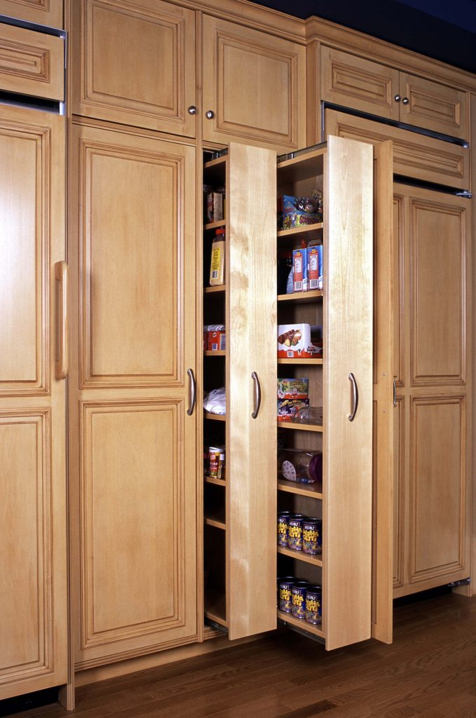 Maple pull-out pantry beside panelled refrigerator doors