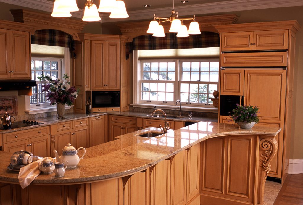 Maple kitchen with a curved granite island and warm pendant lighting