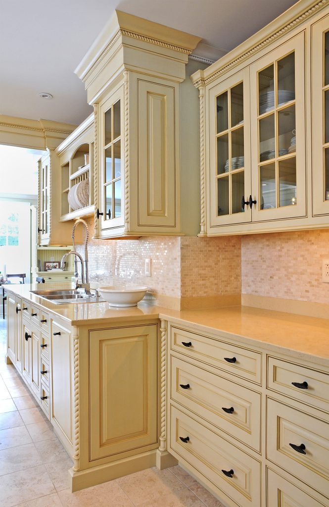 Cream cabinetry with rope-twist pilasters and glass-front uppers