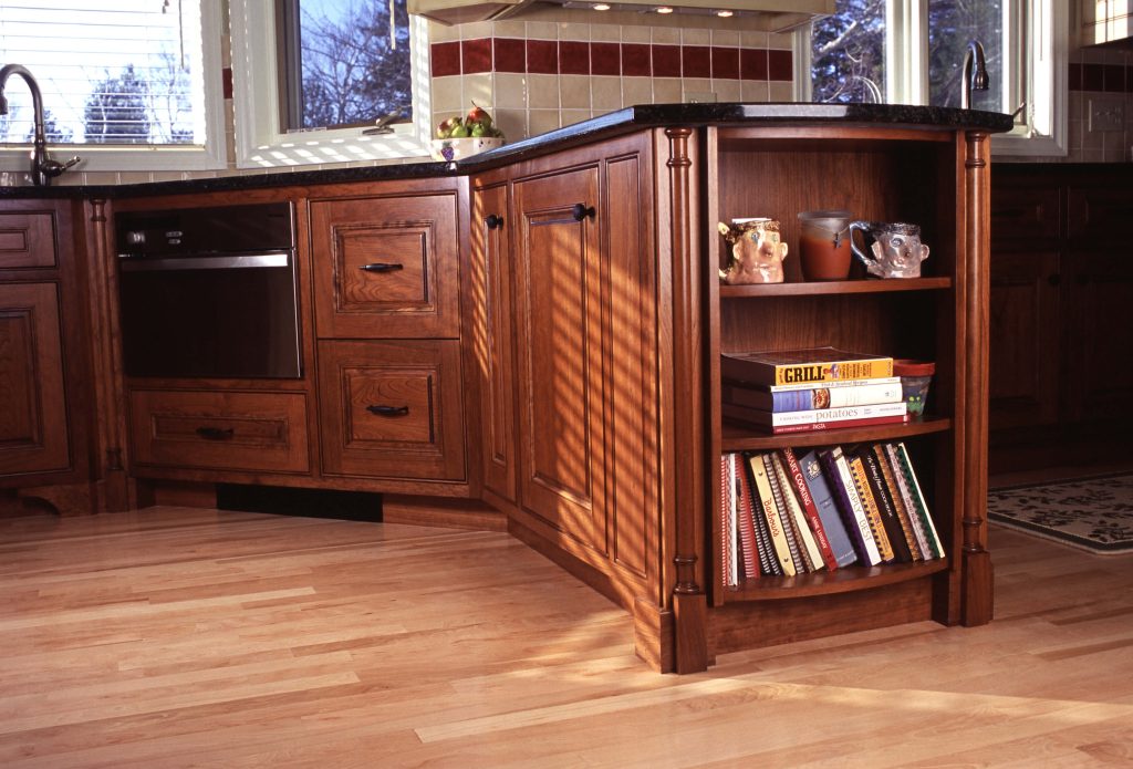 Cherry peninsula with a built-in oven and open cookbook shelves
