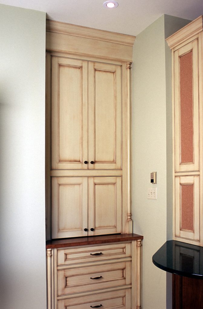 Cream built-in cabinet with raised-panel doors and drawers