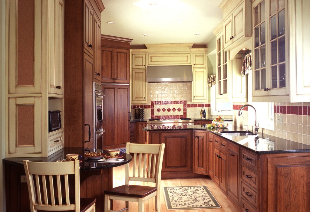 Cherry and cream kitchen with raised-panel cabinets and a tiled backsplash