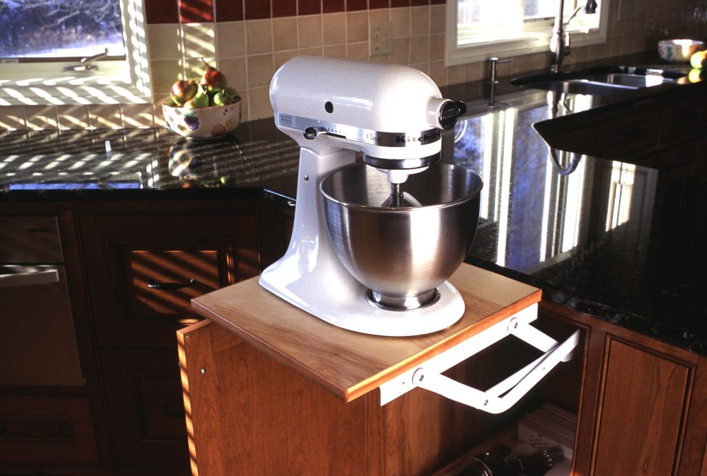 Pop-up mixer lift in a cherry base cabinet