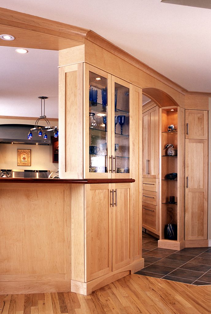 Maple glass-front display cabinet and archway between kitchen and dining room