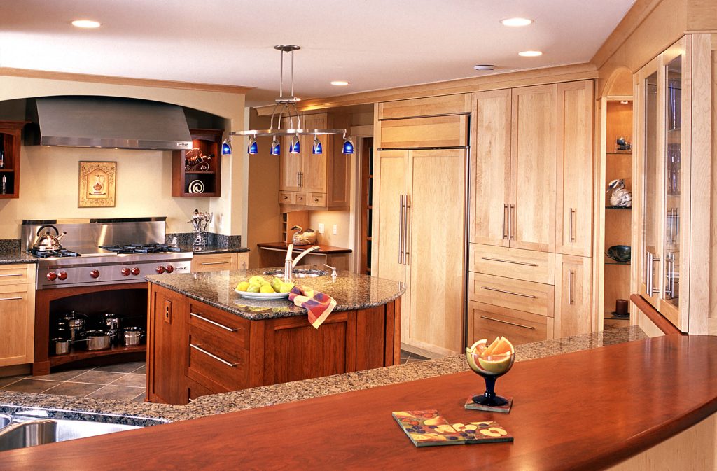 Maple kitchen with a cherry island and bar, a professional range and a panelled refrigerator