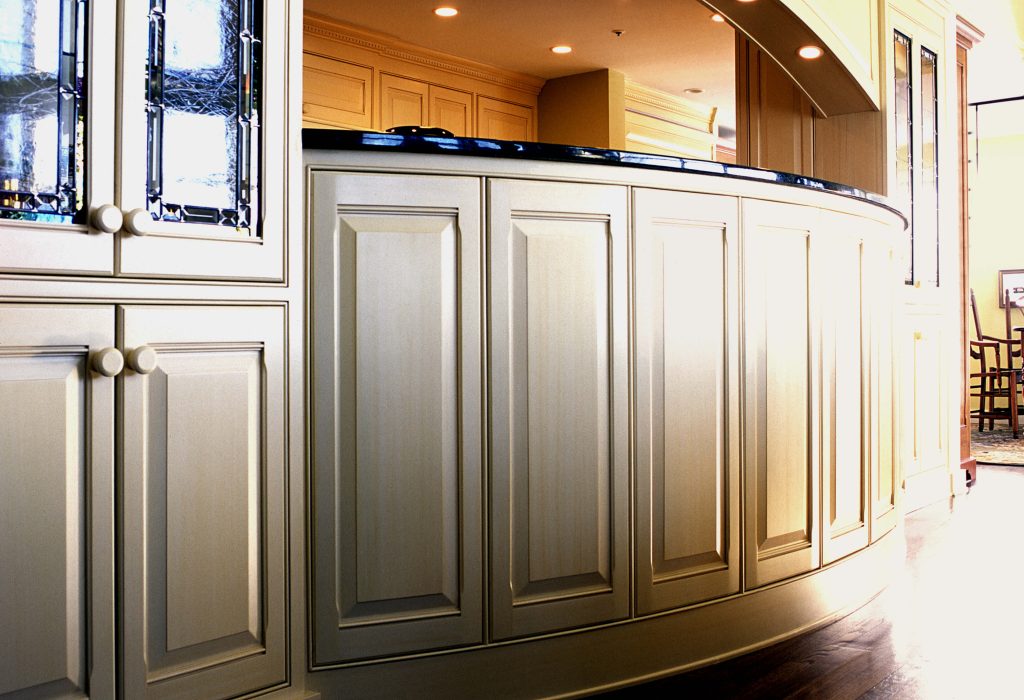Curved cream cabinetry with a black countertop