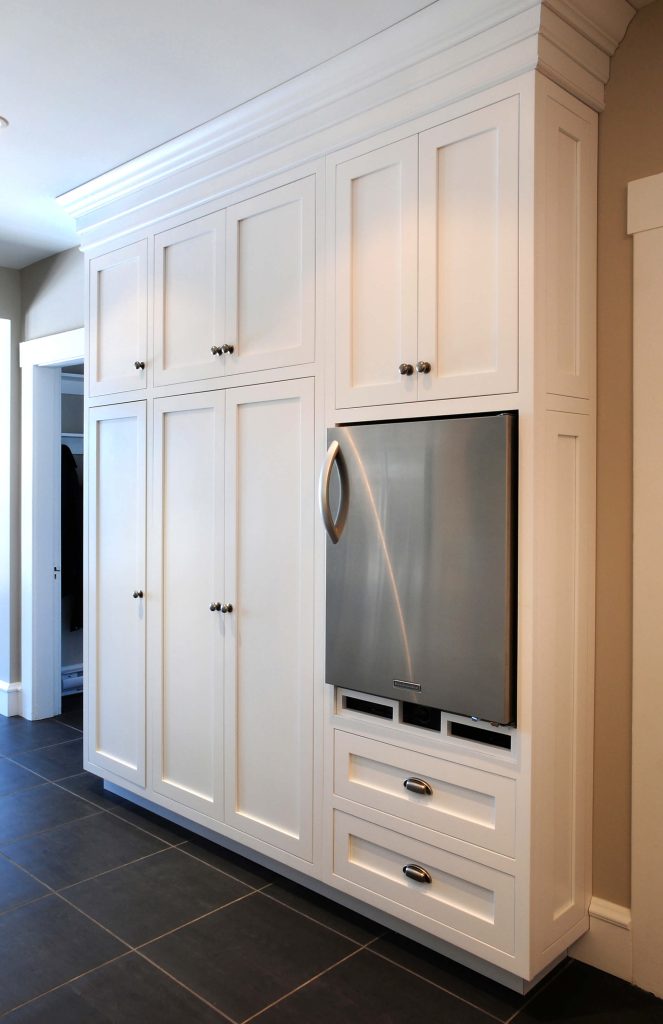Wall of white cabinetry with a built-in refrigerator drawer