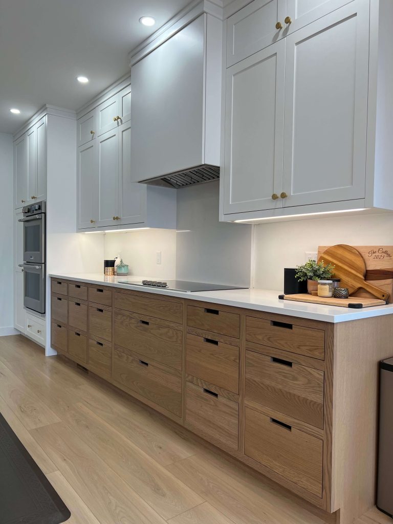Oak lower cabinets and white uppers with built-in wall ovens and a cooktop
