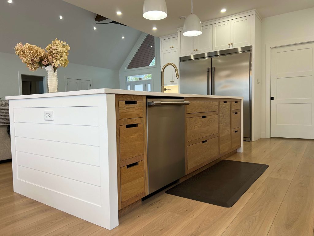 Shiplap-panelled island with oak drawers and a stainless dishwasher
