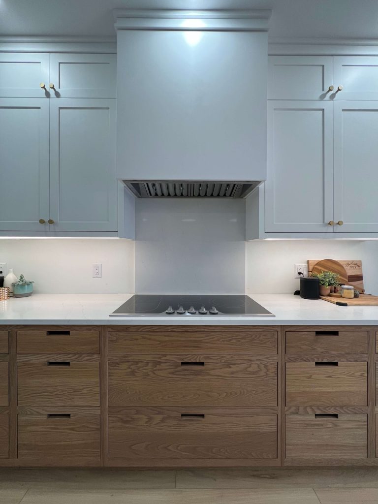 Range wall with a white hood surround, oak drawers and a glass cooktop