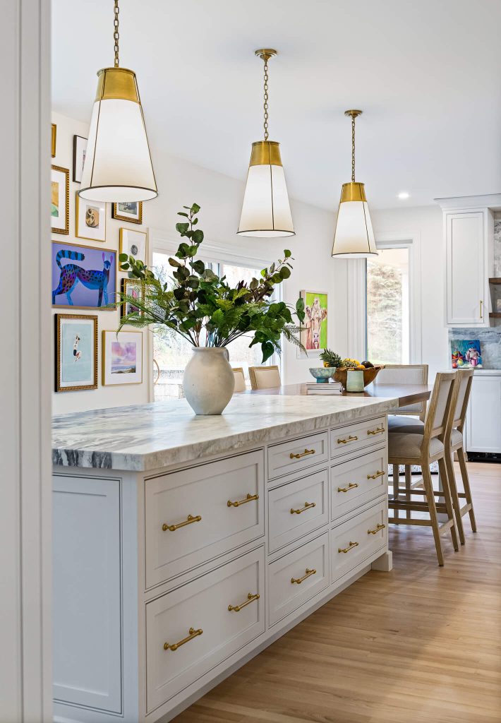 White island with brass hardware, a marble top and counter stools