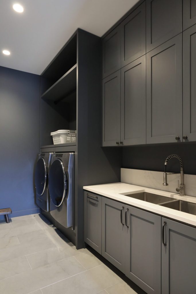 Laundry room with charcoal cabinets, a utility sink and a front-load washer and dryer