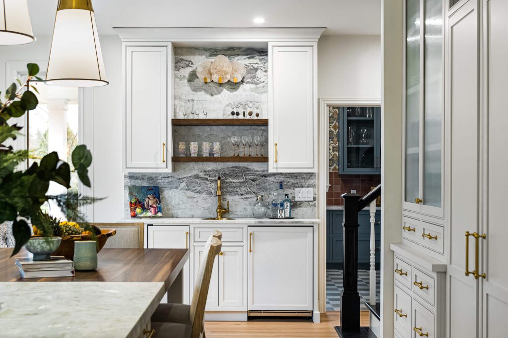White hutch with an open walnut shelf, marble backsplash and a glass-front pantry cabinet