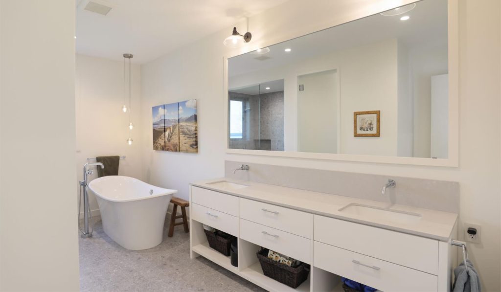 Custom bathroom vanity cabinetry with double sink and freestanding tub at St. Croix Residence