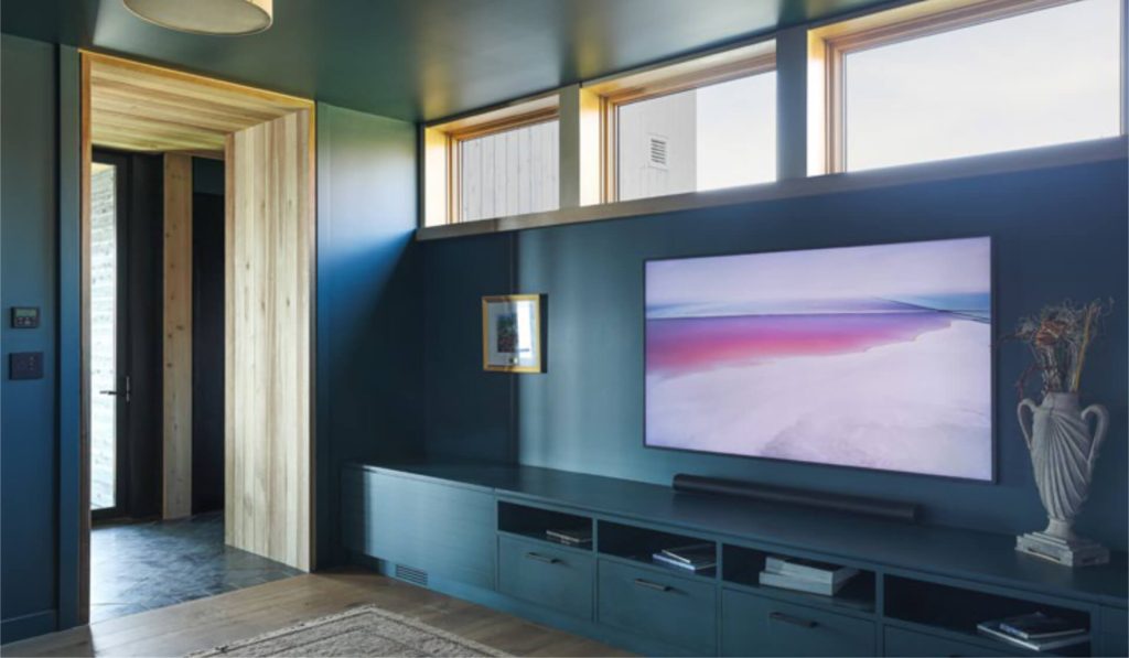Custom living room media cabinetry with integrated storage and TV wall at St. Croix Residence