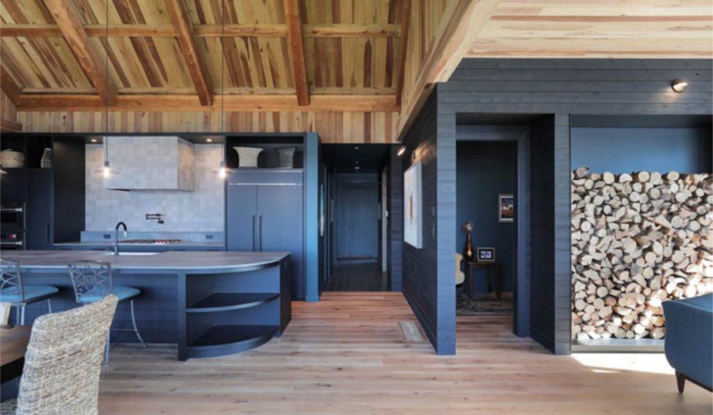 Open-concept kitchen with custom cabinetry, curved island, and dark millwork at St. Croix Residence