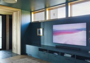 Custom living room media cabinetry with integrated storage and TV wall at St. Croix Residence
