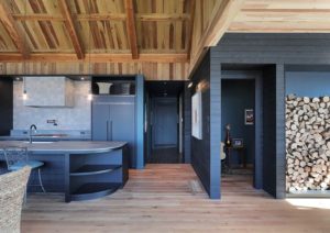 Open-concept kitchen with custom cabinetry, curved island, and dark millwork at St. Croix Residence
